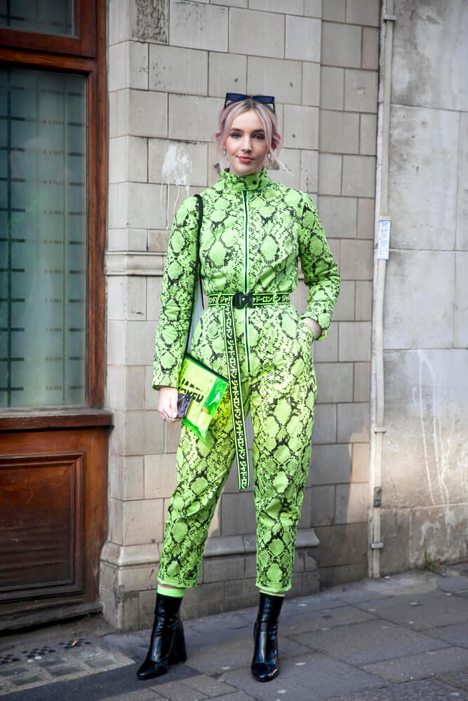 LONDON - FEBRUARY 15, 2019: guest is seen on the street wearing neon green snakeskin pattern jumpsuit with neon bag during London Fashion Week