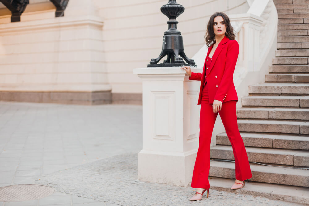 Woman wearing red suit walking down stairs