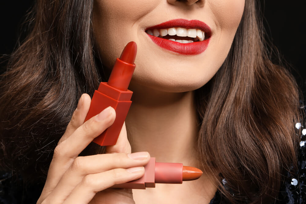 Woman holding 2 lipsticks