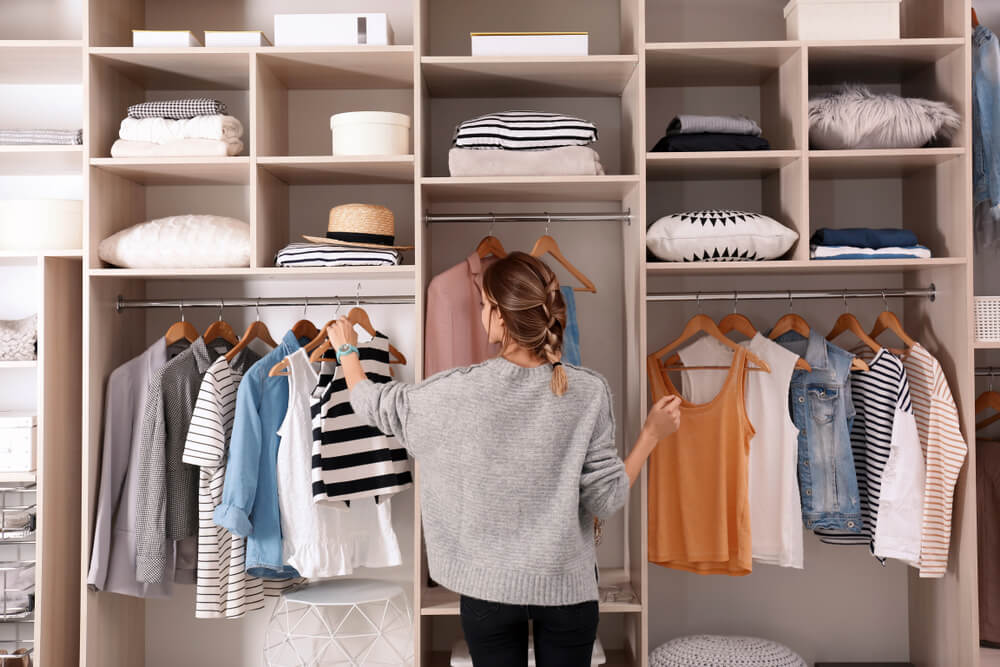 Woman choosing clothes from wardrobe