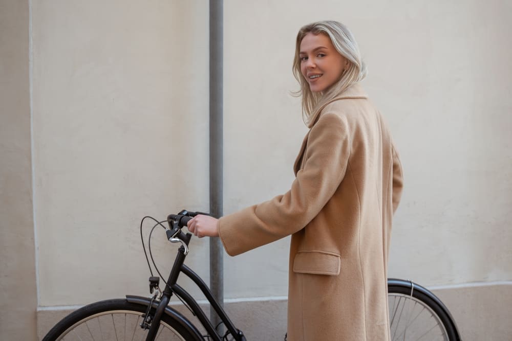 Woman in beige coat with bike