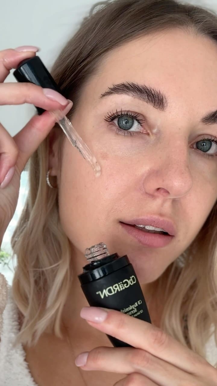 Lady applying CbGardn skincare serum to face for review